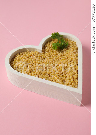 Concept of cooking, uncooked ptitim, on pink background 97772130