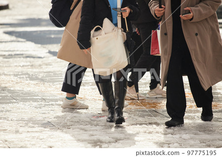 雪融雪地上行走的人影 97775195