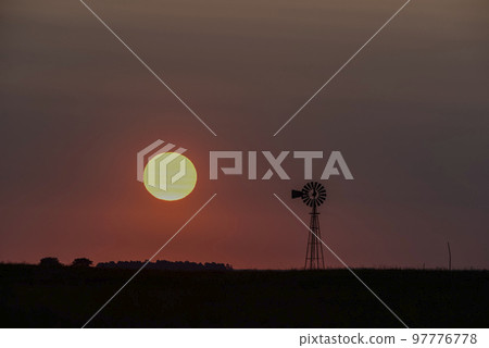 Windmill in countryside at sunset, Pampas, Patagonia,Argentina. 97776778