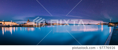 Helsinki, Finland. Light Blue Dramatic Sky With Shining Stars. View Of Embankment With Ferris Wheel And Uspenski Cathedral In Illuminations During Morning Sunrise Time. Panoramic View, Panorama 97776916