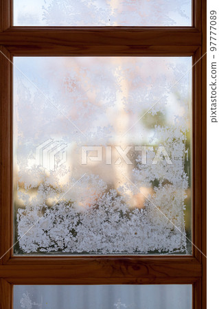 Frost is on the window glass in wooden frame, vertical photo Frost is on the window glass in wooden frame, vertical photo 97777089