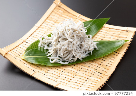 黑色背景中用漏勺盛放的鍋炸銀魚 97777254