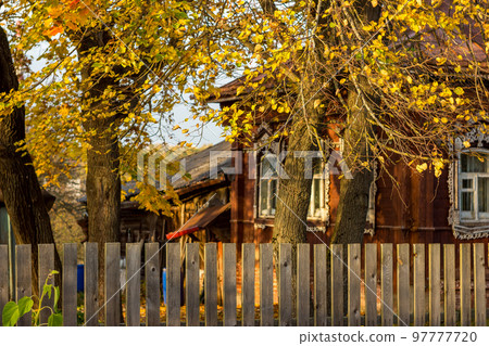 Village house with a fence, picturesque autumn view 97777720