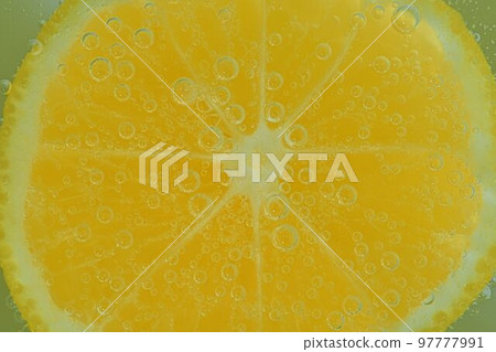 Close-up of lemon in liquid with bubbles. Slice of yellow ripe lemon in sparkling water. Juicy citrus in carbonated water. Macro image Close-up of lemon in liquid with bubbles. Slice of yellow ripe lemon in sparkling water. Juicy citrus in carbonated water. Macro image 97777991