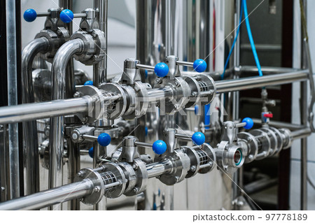Close-up of steel tanks with chemical materials with pipes with levers in production factory Close-up of steel tanks with chemical materials with pipes with levers in production factory 97778189