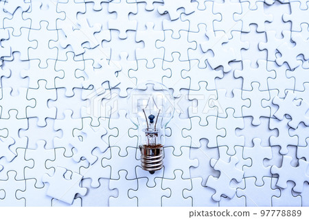 Sparking ideas Background textures of scattered jigsaw puzzles and light bulbs Strategies Cold colors 97778889