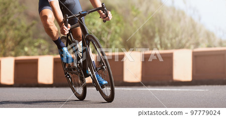 Road bike cyclist man cycling, athlete on a race bike. Leaning into a corner Road bike cyclist man cycling, athlete on a race bike. Leaning into a corner 97779024