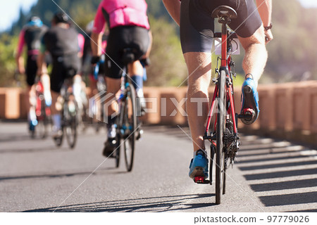 Group of cyclist at professional race, cyclists in a road race stage. Climbing the hill Group of cyclist at professional race, cyclists in a road race stage. Climbing the hill 97779026