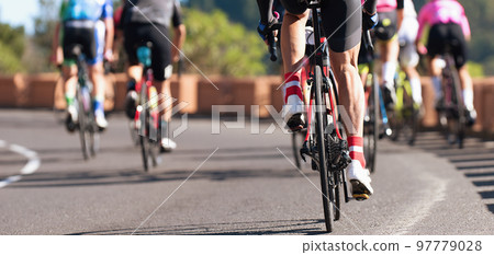 Group of cyclist at professional race, cyclists in a road race stage. Climbing the hill Group of cyclist at professional race, cyclists in a road race stage. Climbing the hill 97779028