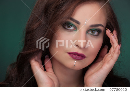 Girl with green eye shadows, make-up, facial stones crystals 97780020