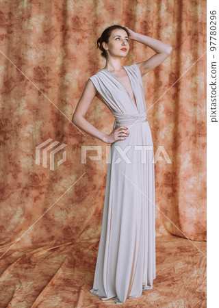Nice woman with elegant Hairstyle. Brunette Fashion Model Woman wearing Summer Prom long maxi transformer Dress 97780296