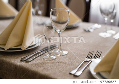 empty goblets and other cutlery are served on the festive table. empty goblets and other cutlery are served on the festive table. 97780627
