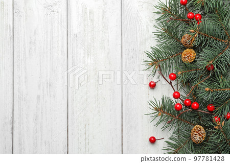 Flat lay composition with fir branches and berries on white wooden background, space for text. Winter holidays 97781428
