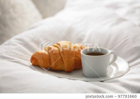 Delicious morning coffee and croissant on bed 97781660