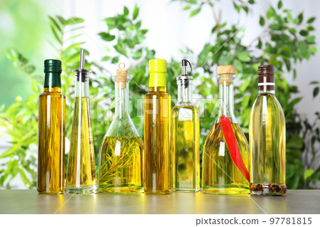 Different sorts of cooking oil in bottles on light grey table Different sorts of cooking oil in bottles on light grey table 97781815