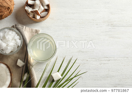 Flat lay composition with coconut oil on white wooden table, space for text 97781867