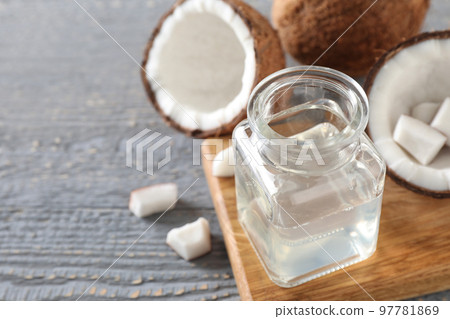Coconut oil on grey wooden table, closeup, space for text 97781869