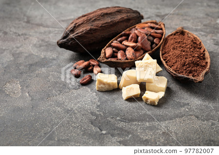 Organic cocoa butter, beans and powder on grey table Organic cocoa butter, beans and powder on grey table 97782007