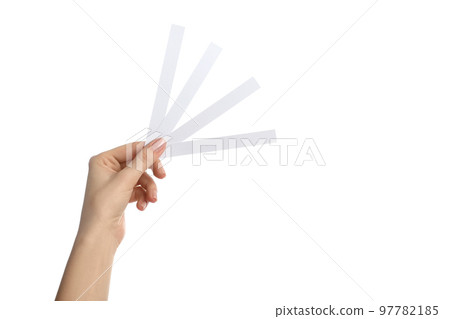 Woman holding perfume testing strips on white background, closeup Woman holding perfume testing strips on white background, closeup 97782185
