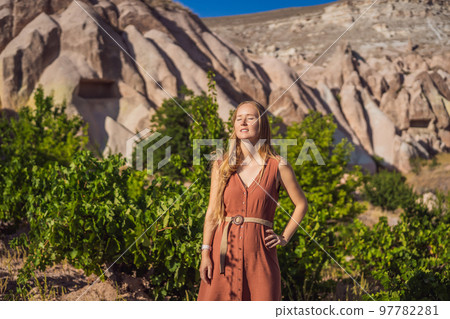 Young woman exploring valley with rock formations and fairy caves near Goreme in Cappadocia Turkey 97782281