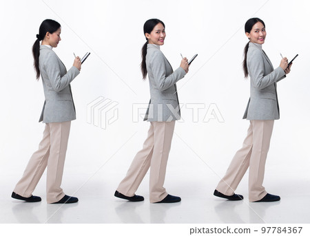 Full Length 20s Asian Woman wear formal business blazer suit  dress pant shoes. Black long straight hair female hold tablet work confident, walking forward turn left right, white background isolated 97784367