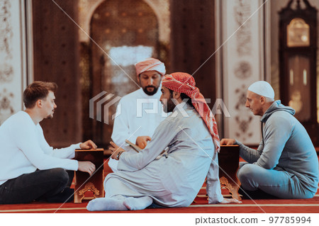 A group of Muslims reading the holy book of the Quran in a modern mosque during the Muslim holiday of Ramadan 97785994