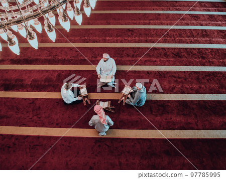 A group of Muslims reading the holy book of the Quran in a modern mosque during the Muslim holiday of Ramadan A group of Muslims reading the holy book of the Quran in a modern mosque during the Muslim holiday of Ramadan 97785995