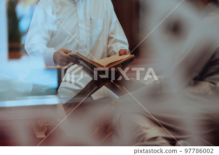 A group of Muslims reading the holy book of the Quran in a modern mosque during the Muslim holiday of Ramadan A group of Muslims reading the holy book of the Quran in a modern mosque during the Muslim holiday of Ramadan 97786002