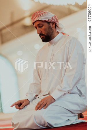 A Muslim praying in a modern mosque during the holy Muslim month of Ramadan 97786004