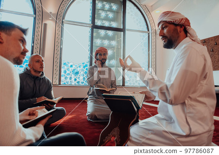 A group of Muslims reading the holy book of the Quran in a modern mosque during the Muslim holiday of Ramadan 97786087