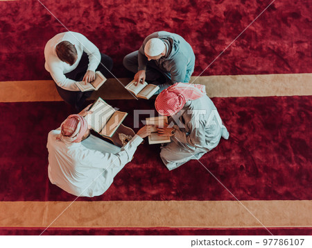 A group of Muslims reading the holy book of the Quran in a modern mosque during the Muslim holiday of Ramadan 97786107