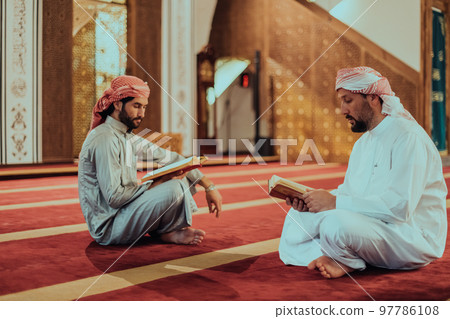 A group of Muslims reading the holy book of the Quran in a modern mosque during the Muslim holiday of Ramadan 97786108
