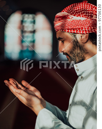 Muslim Arabic man praying. Religious muslim man praying inside the mosque during ramadan Muslim Arabic man praying. Religious muslim man praying inside the mosque during ramadan 97786130