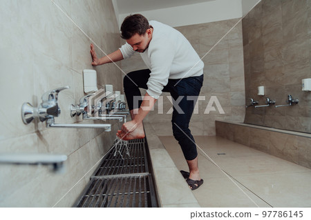 A Muslim performing ablution. Ritual religious cleansing of Muslims before performing prayer. The process of cleansing the body before prayer 97786145