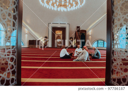 A group of Muslims reading the holy book of the Quran in a modern mosque during the Muslim holiday of Ramadan 97786187