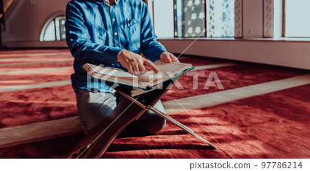 A Muslim reads the holy Islamic book Quraqn in a modern grand mosque during the Muslim holy month of Ranazan A Muslim reads the holy Islamic book Quraqn in a modern grand mosque during the Muslim holy month of Ranazan 97786214