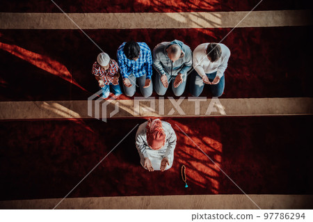 A group of Muslims in a modern mosque praying the Muslim prayer namaz, during the holy month of Ramadan 97786294