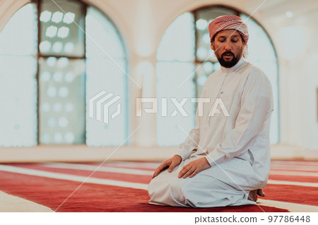 A Muslim praying in a modern mosque during the holy Muslim month of Ramadan 97786448