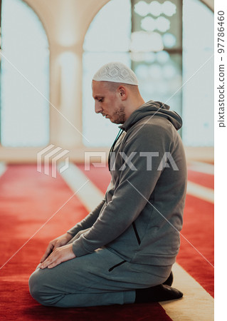 A Muslim praying in a modern mosque during the holy Muslim month of Ramadan A Muslim praying in a modern mosque during the holy Muslim month of Ramadan 97786460