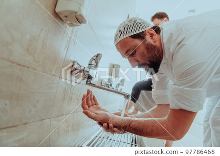 A Muslim performing ablution. Ritual religious cleansing of Muslims before performing prayer. The process of cleansing the body before prayer 97786468
