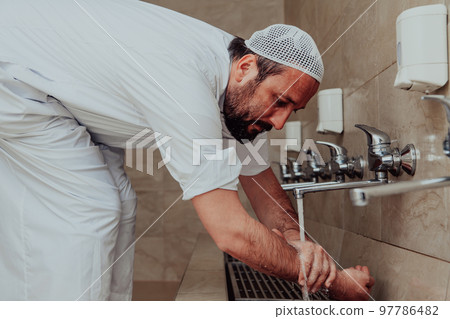 A Muslim performing ablution. Ritual religious cleansing of Muslims before performing prayer. The process of cleansing the body before prayer 97786482