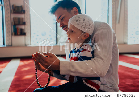 Muslim prayer father and son in mosque prayingtogether Muslim prayer father and son in mosque prayingtogether 97786523