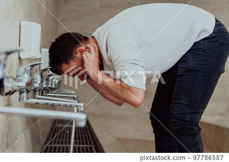 A Muslim performing ablution. Ritual religious cleansing of Muslims before performing prayer. The process of cleansing the body before prayer 97786587