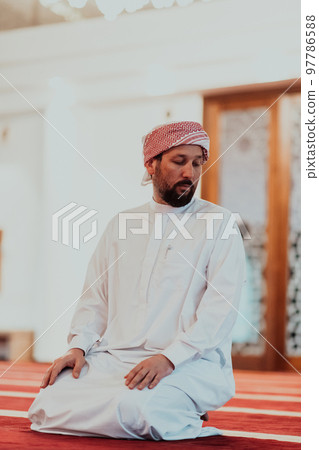 A Muslim praying in a modern mosque during the holy Muslim month of Ramadan 97786588
