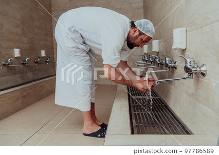 A Muslim performing ablution. Ritual religious cleansing of Muslims before performing prayer. The process of cleansing the body before prayer 97786589