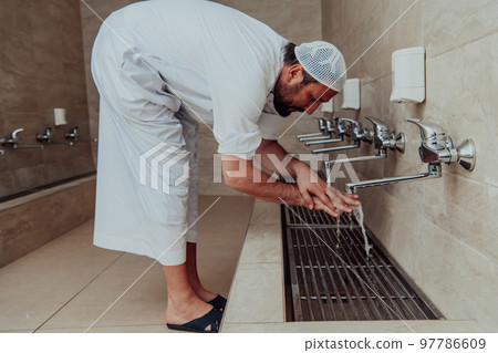A Muslim performing ablution. Ritual religious cleansing of Muslims before performing prayer. The process of cleansing the body before prayer 97786609