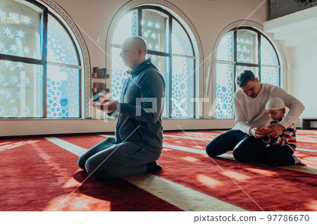 A group of Muslims in a modern mosque praying the Muslim prayer namaz, during the holy month of Ramadan 97786670