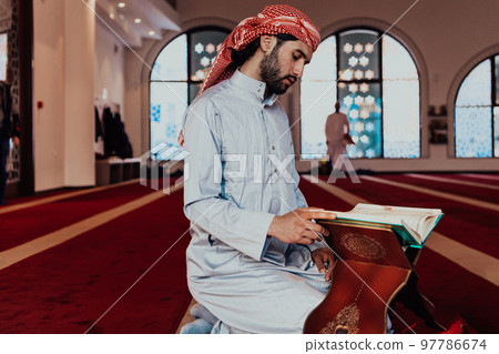A Muslim reads the holy Islamic book Quraqn in a modern grand mosque during the Muslim holy month of Ranazan 97786674