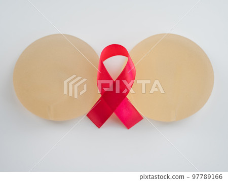 Breast implants and satin ribbon. Breast cancer awareness symbol. 97789166
