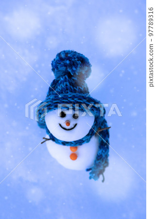 A snowman looking up at the falling snow 97789316